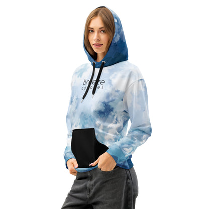 Woman wearing hoodie with a blue watercolor-style design, black pocket, black drawstrings, and a black 'breeze apparel' logo on the chest.