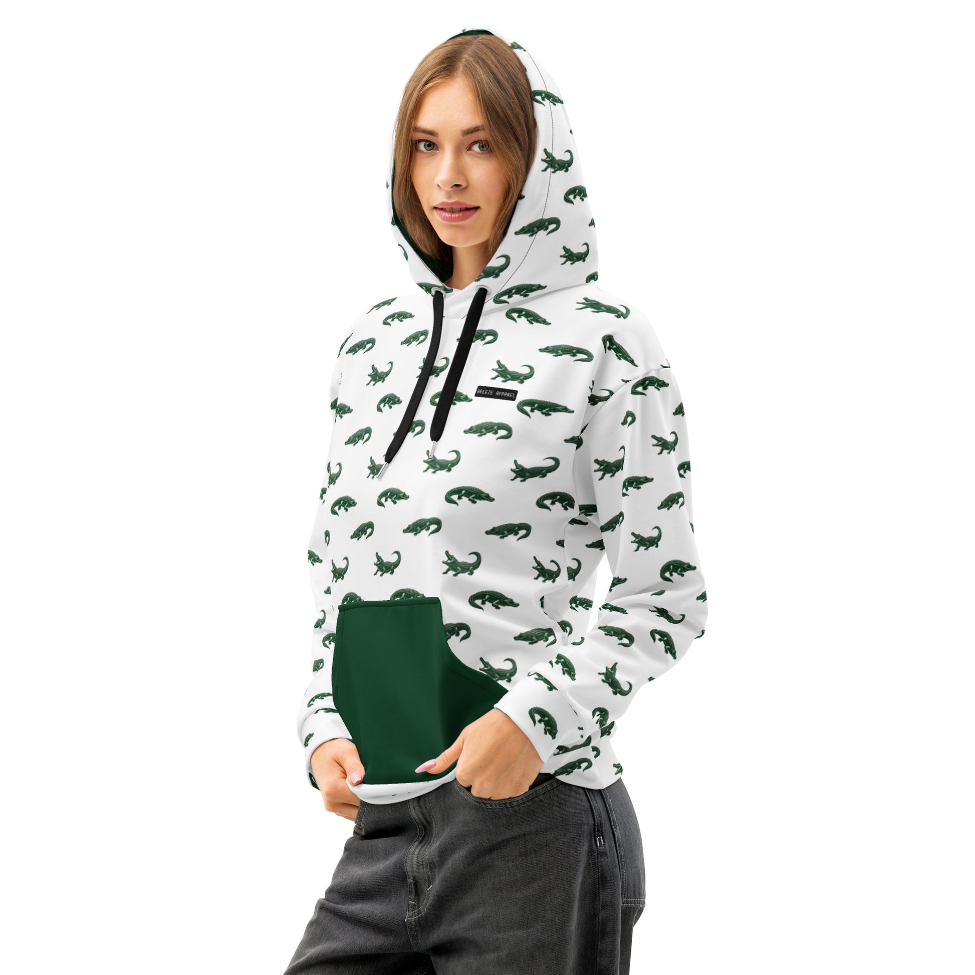 Woman wearing white sweatshirt with pattern of green alligators. Hood interior and pocket are green, drawstrings are black.