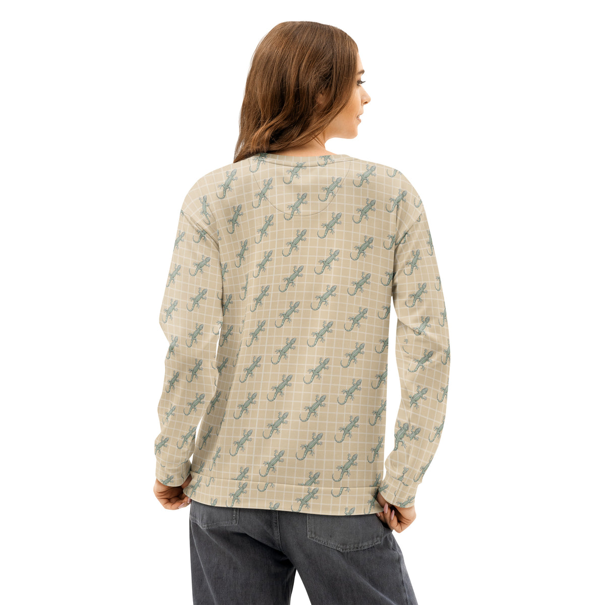 Rear view of woman wearing beige sweatshirt with pattern of green geckos. 