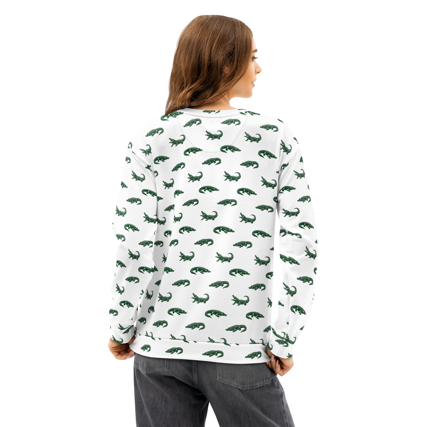 Woman wearing white sweatshirt with pattern of green alligators.