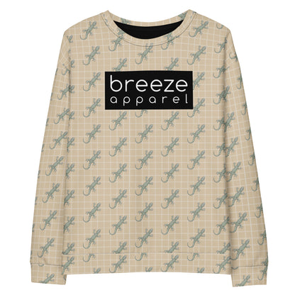 Beige sweatshirt with pattern of green geckos. Across chest is black, rectangular logo with white lettering.