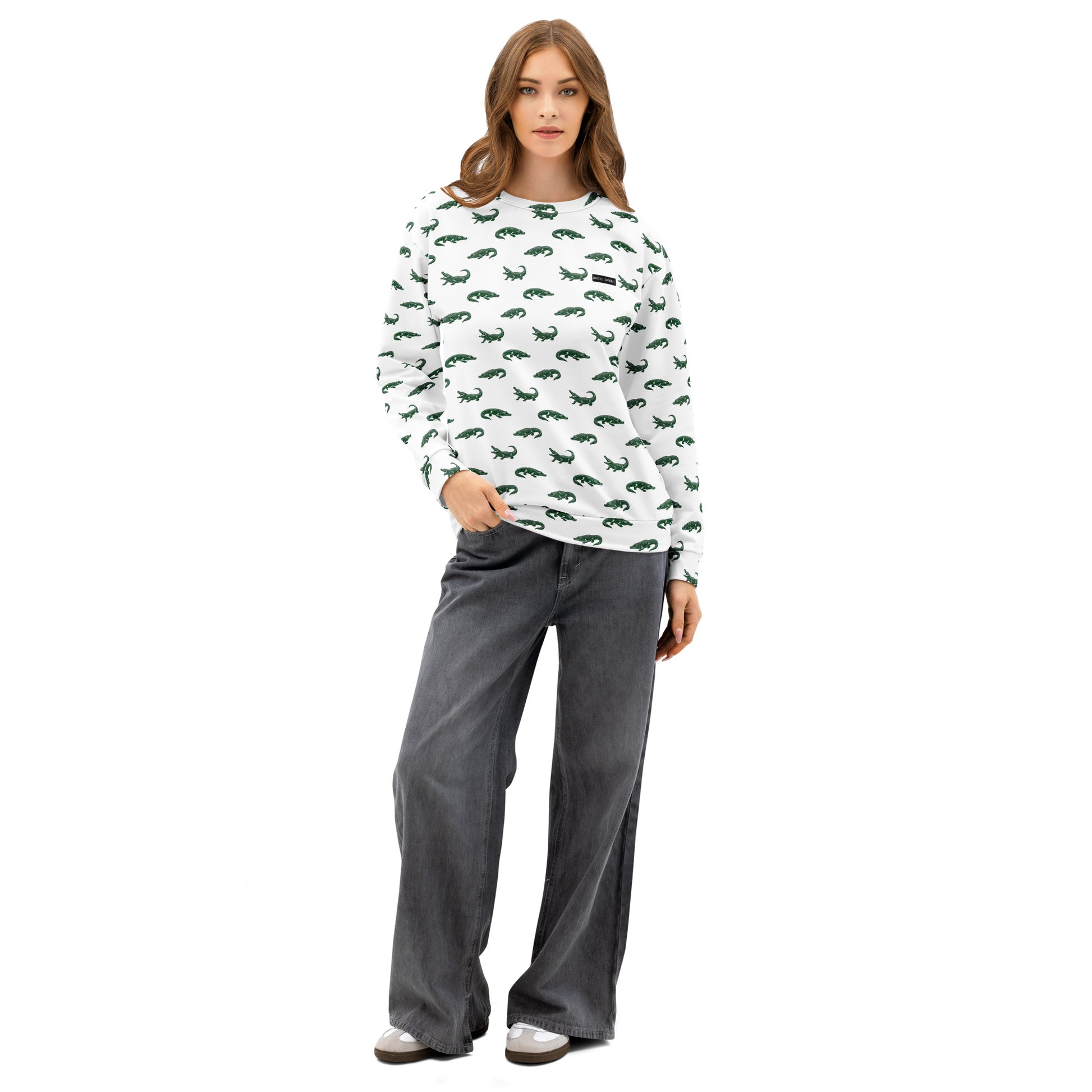 Woman wearing white sweatshirt with pattern of green alligators.