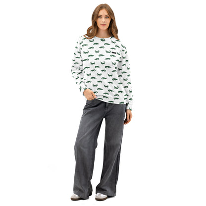Woman wearing white sweatshirt with pattern of green alligators.