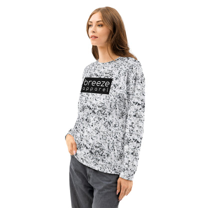 Woman wearing a white sweatshirt with black splotches, resembling a marble countertop. Across the chest is a black rectangle with 'breeze apparel' written in white.