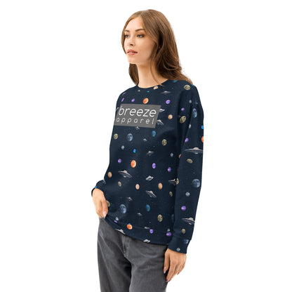Woman wearing sweatshirt with pattern of UFOs and planets in space. Chest is overlaid with gray, rectangular logo with white lettering.