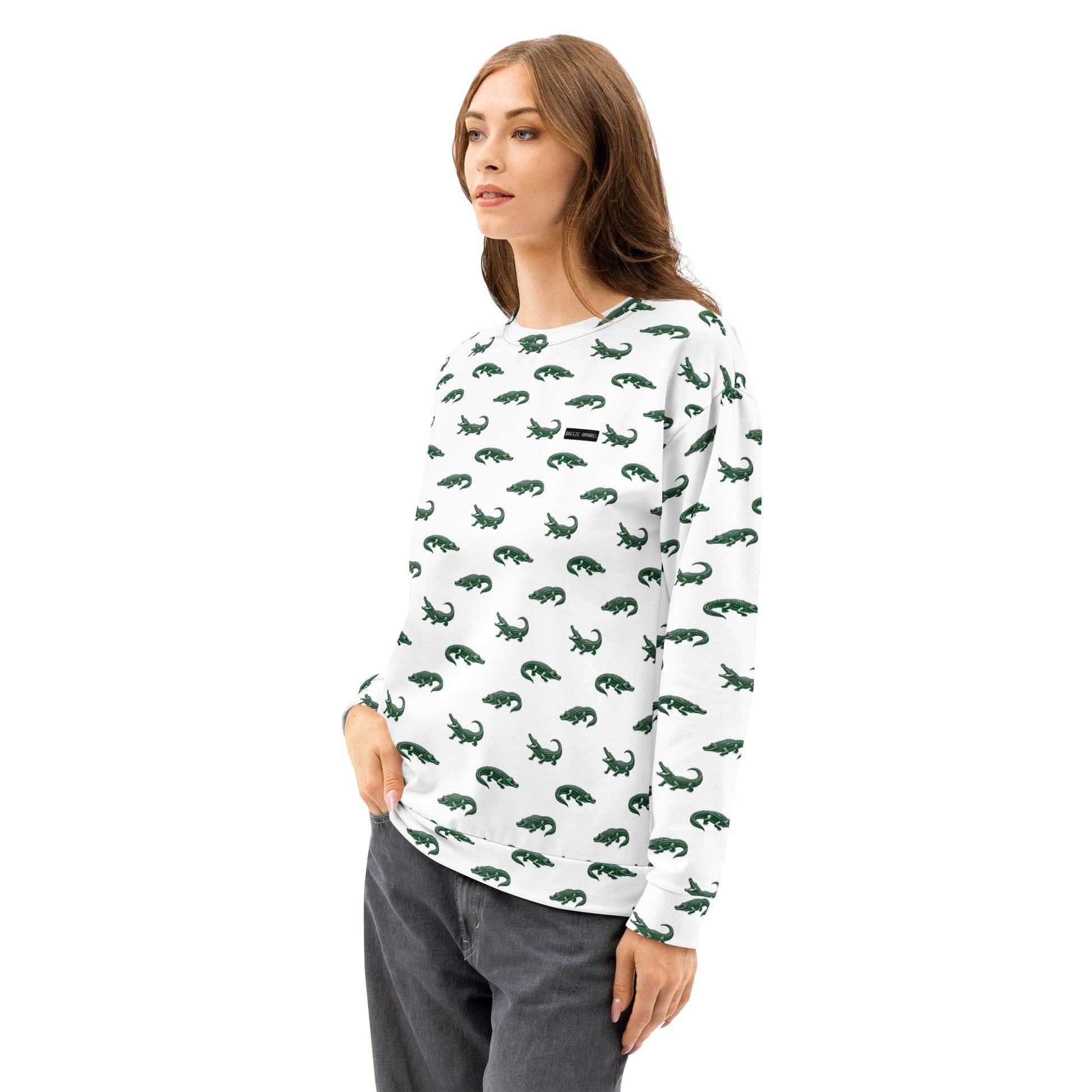Woman wearing white sweatshirt with pattern of green alligators.