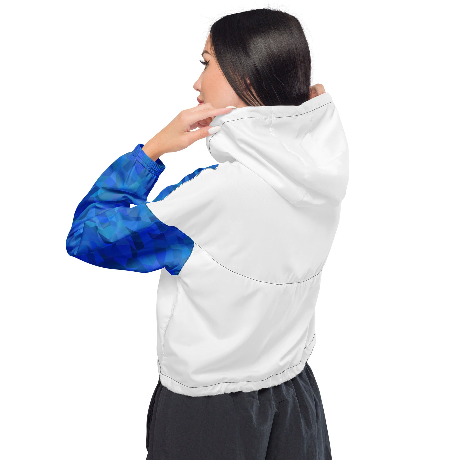 Rear view of woman wearing cropped jacket that has white back and blue geometric pattern on sleeves.