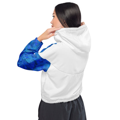 Rear view of woman wearing cropped jacket that has white back and blue geometric pattern on sleeves.