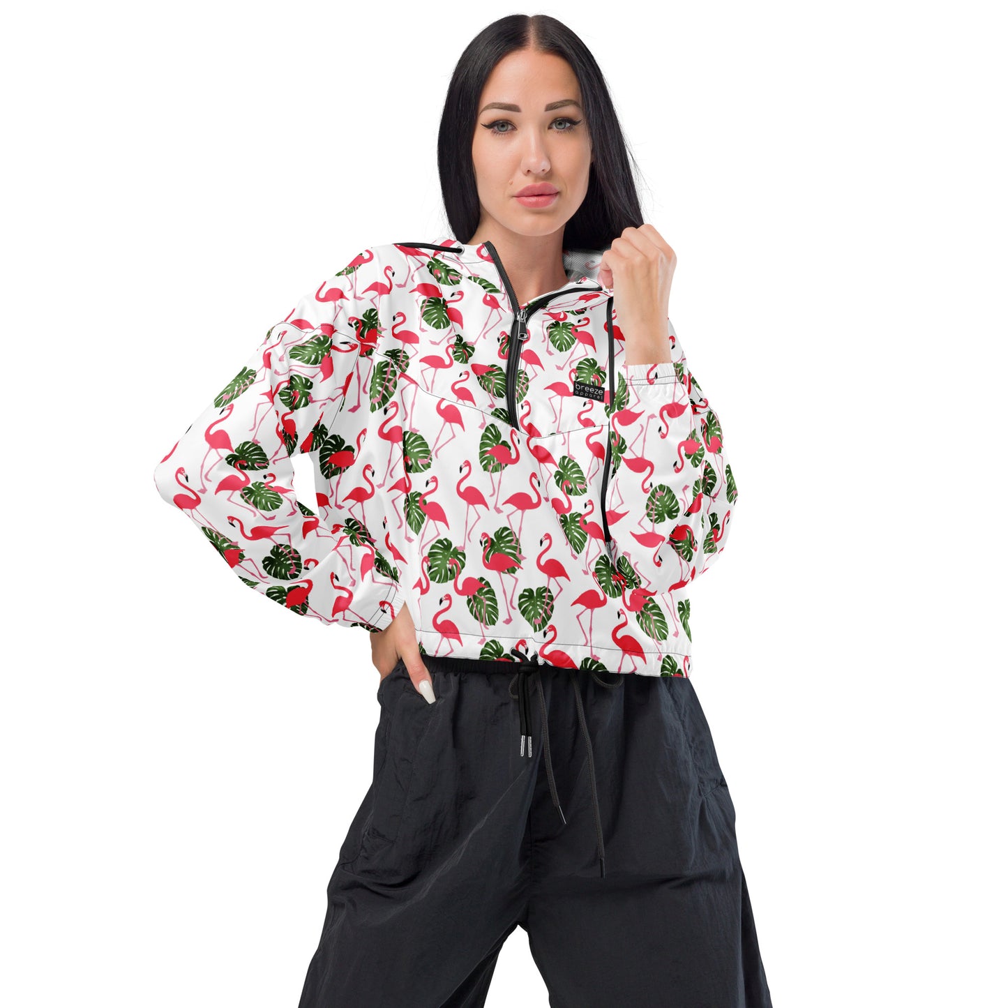 Woman wearing cropped jacket with pattern of flamingos on a white background.