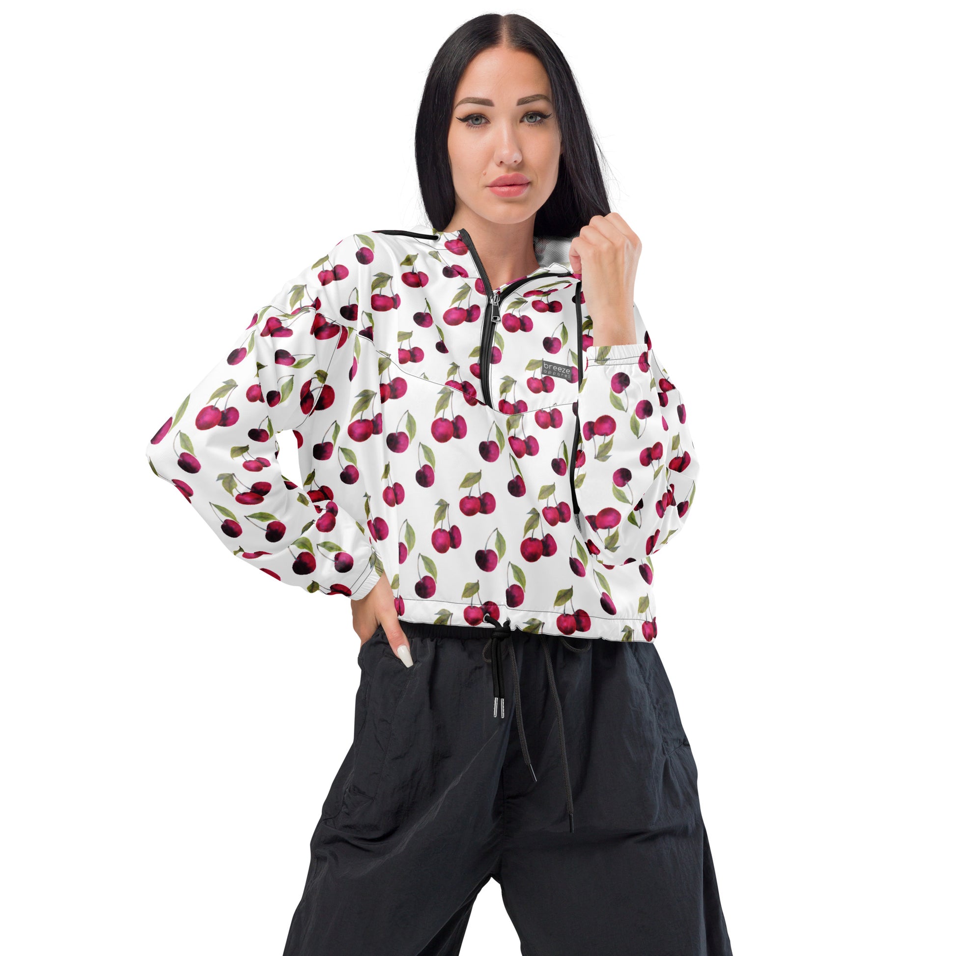 Woman wearing jacket with pattern of cherries on a white background.