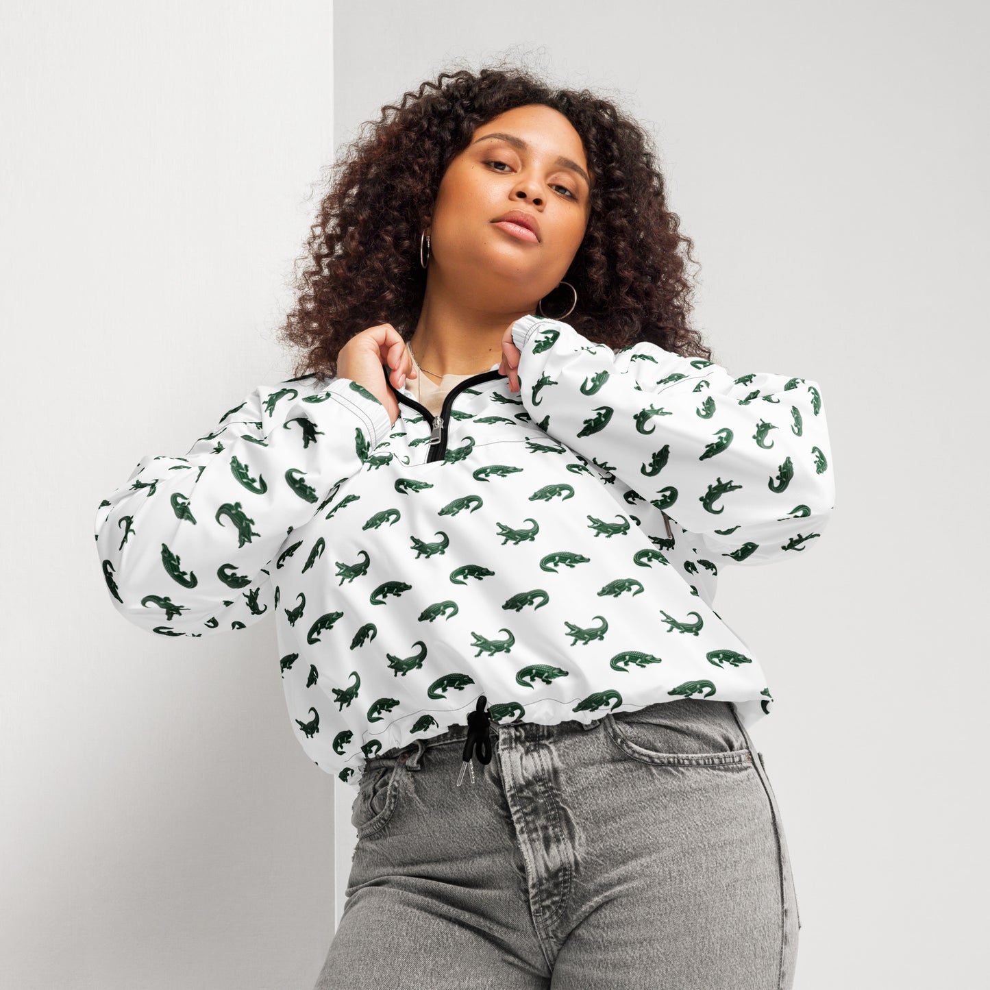 Woman wearing white, cropped windbreaker with pattern of green alligators.