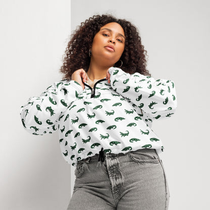 Woman wearing white, cropped windbreaker with pattern of green alligators.