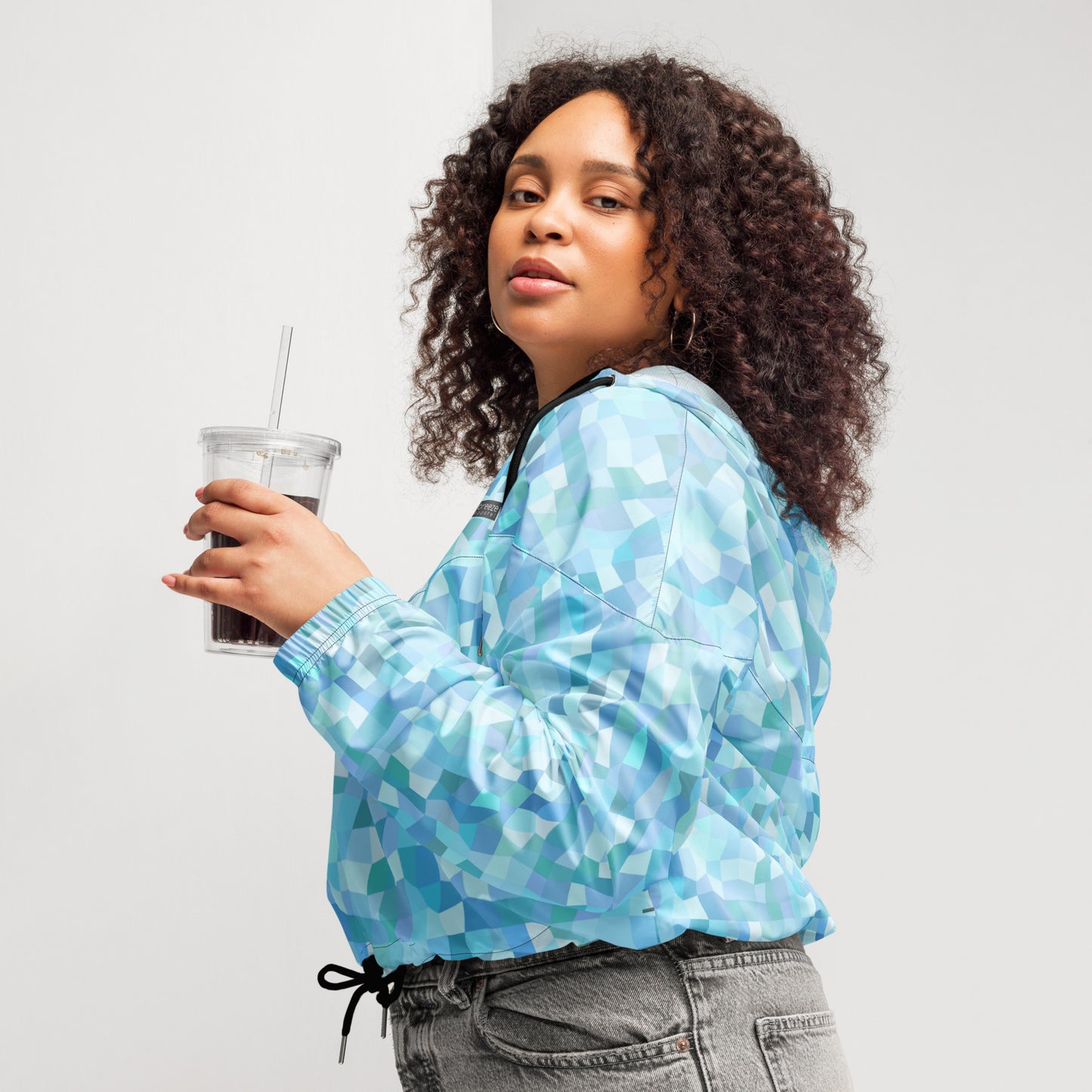 Woman wearing cropped jacket with light-blue geometric pattern.