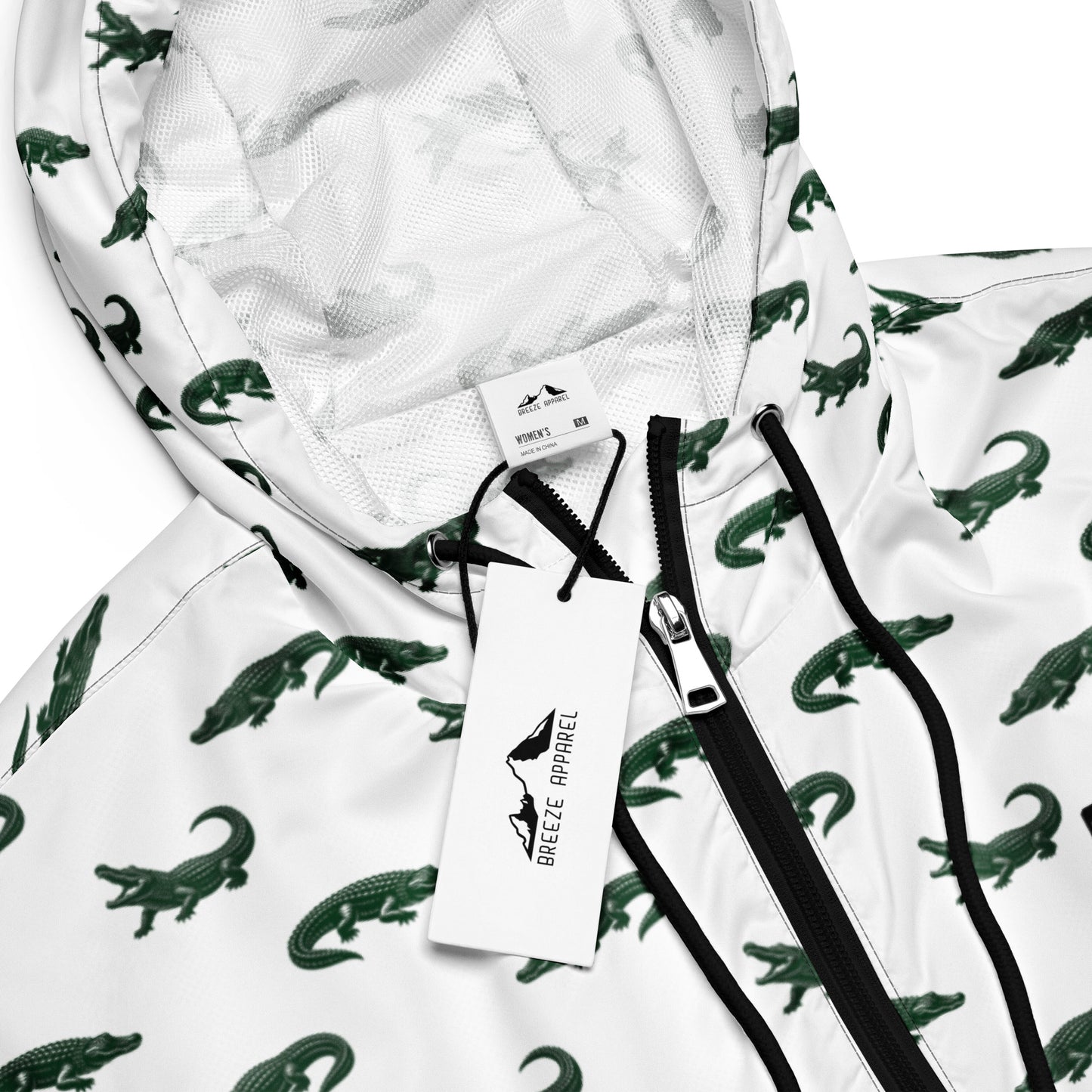White, cropped windbreaker with pattern of green alligators.