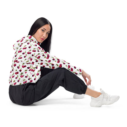 Woman wearing jacket with pattern of cherries on a white background.