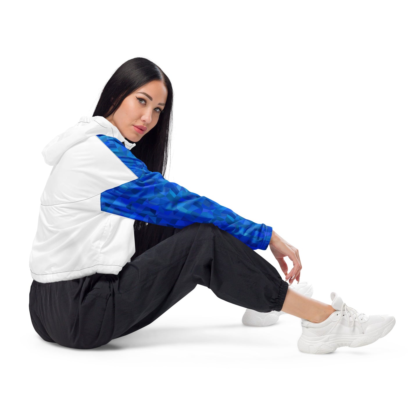 Woman wearing cropped jacket with blue geometric pattern on top and sleeves; rest is white.