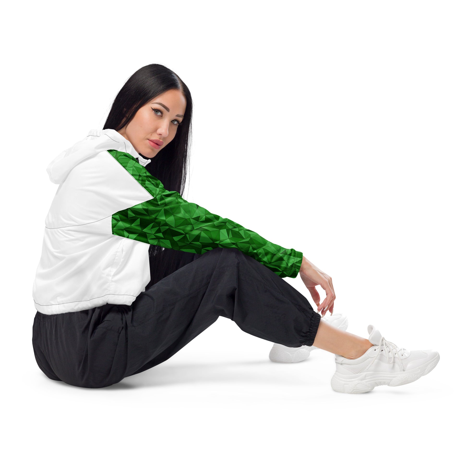 Side view of woman wearing cropped windbreaker that's white, except for a green geometric pattern on sleeves.