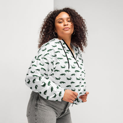 Woman wearing white, cropped windbreaker with pattern of green alligators.