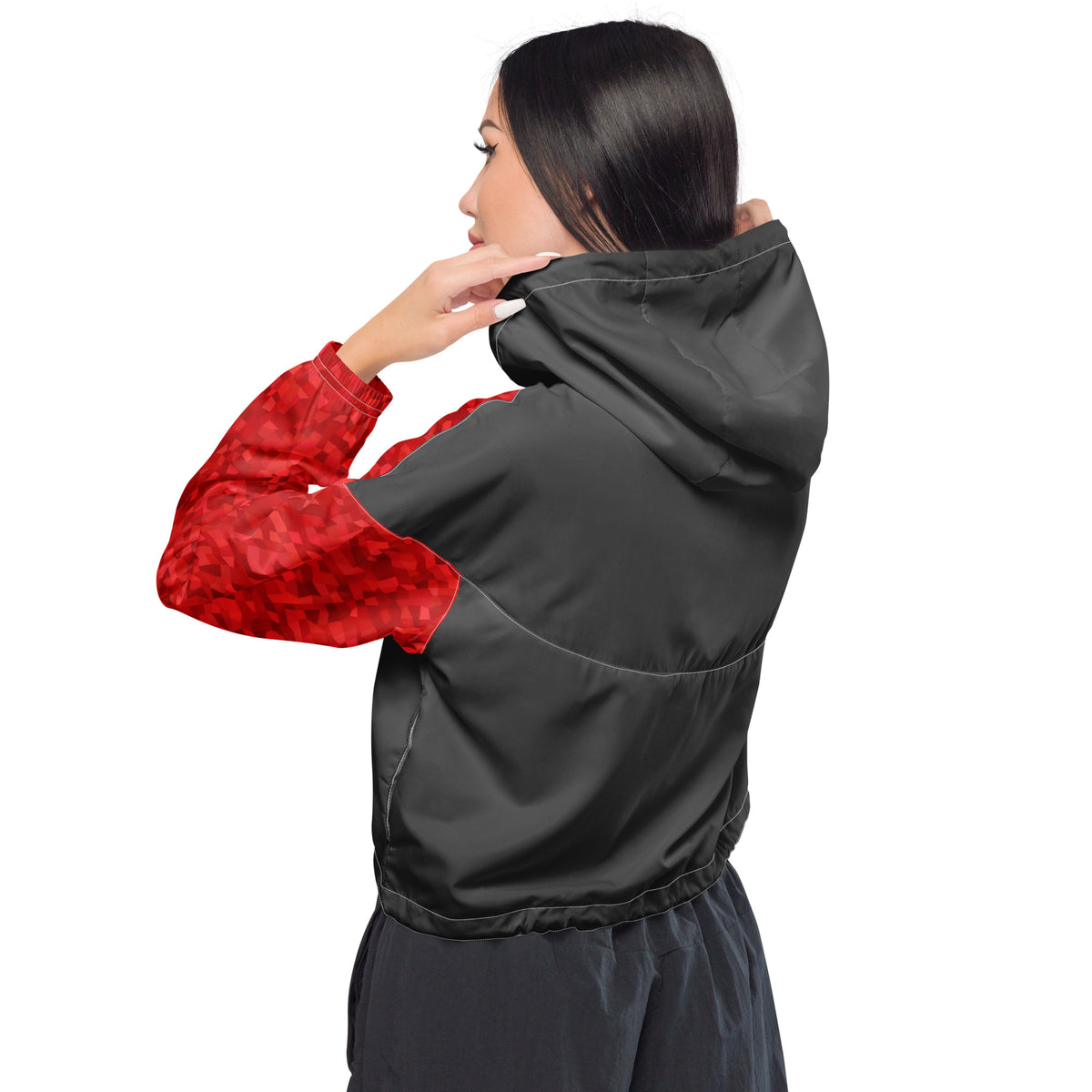 Rear view of man wearing cropped jacket that has gray back and red geometric pattern on sleeves.