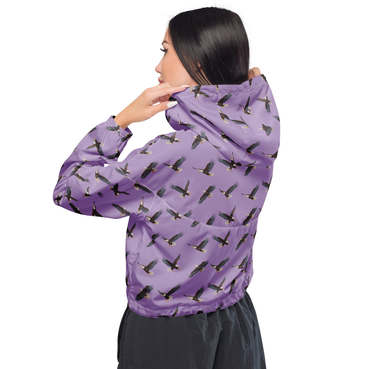 Woman wearing cropped, purple windbreaker with pattern of bald eagles.