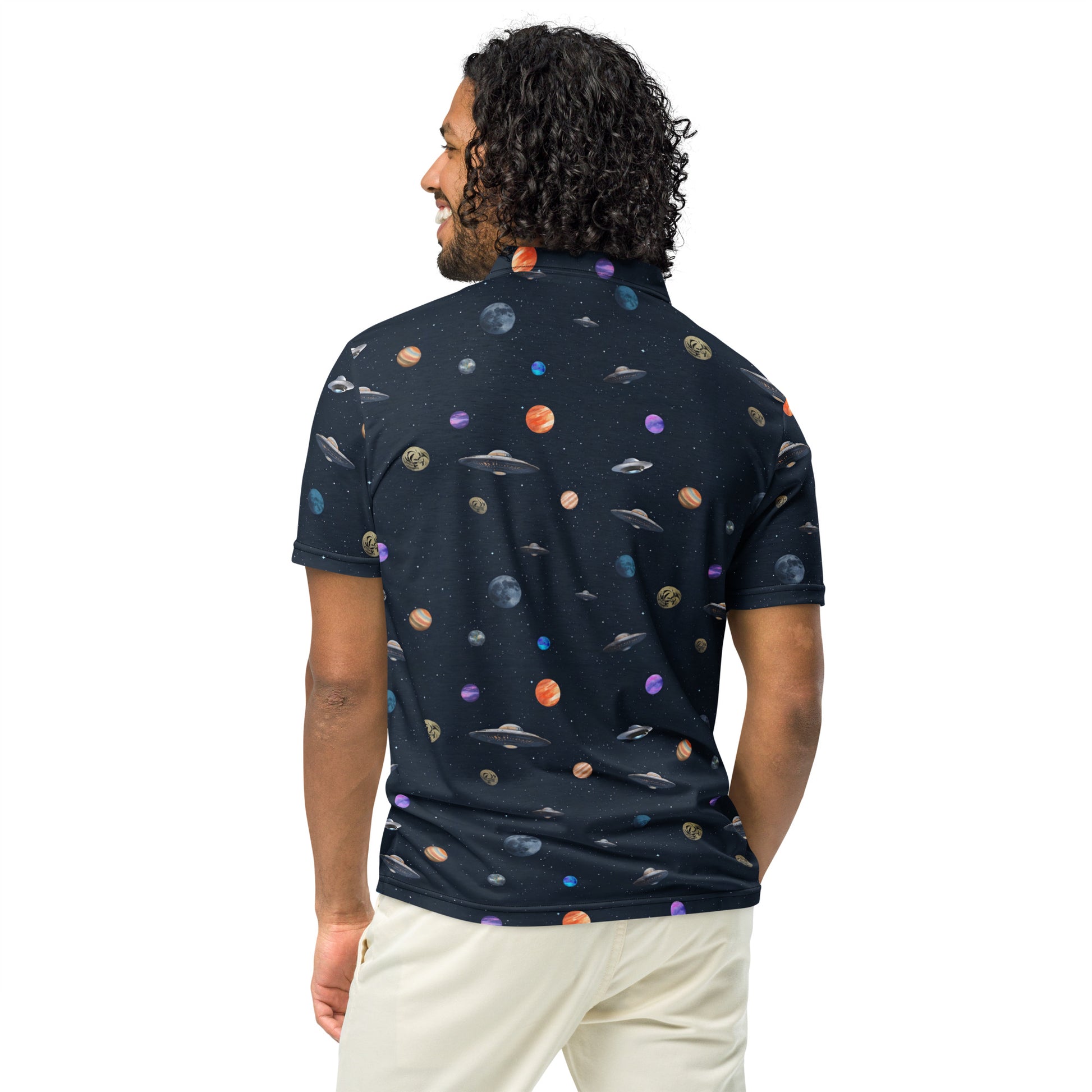 Man wearing polo shirt with pattern of UFOs and planets in space.