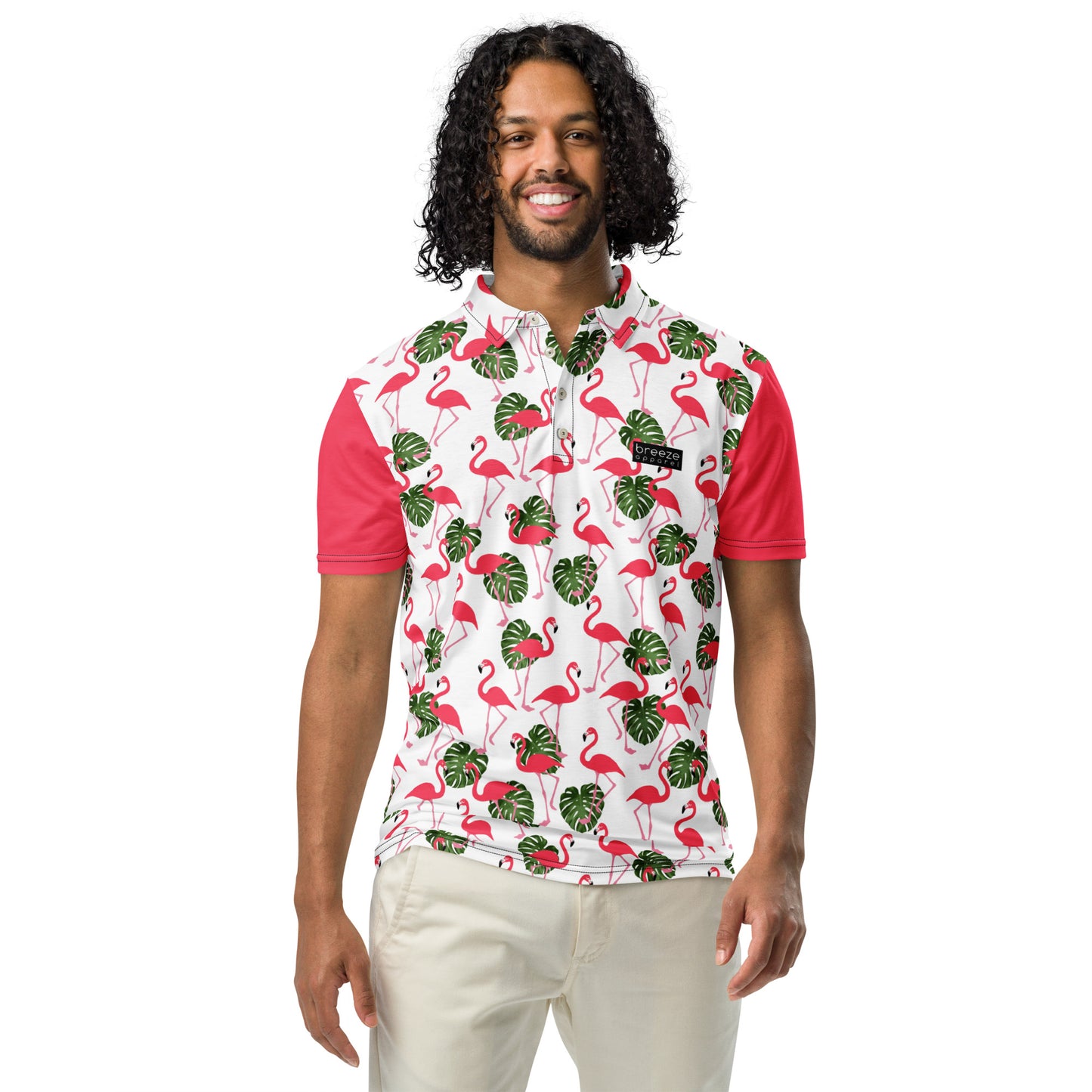 Man wearing polo with pattern of pink flamingos and green palm leaves set on a white background. Sleeves are pink.