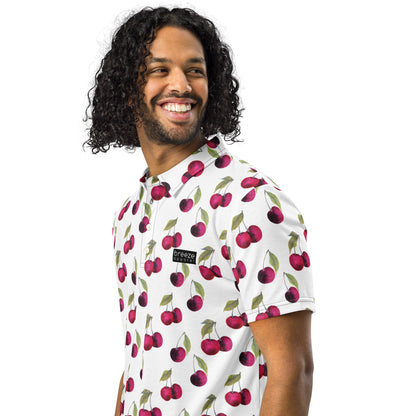 Man wearing polo with pattern of cherries set on a white background.