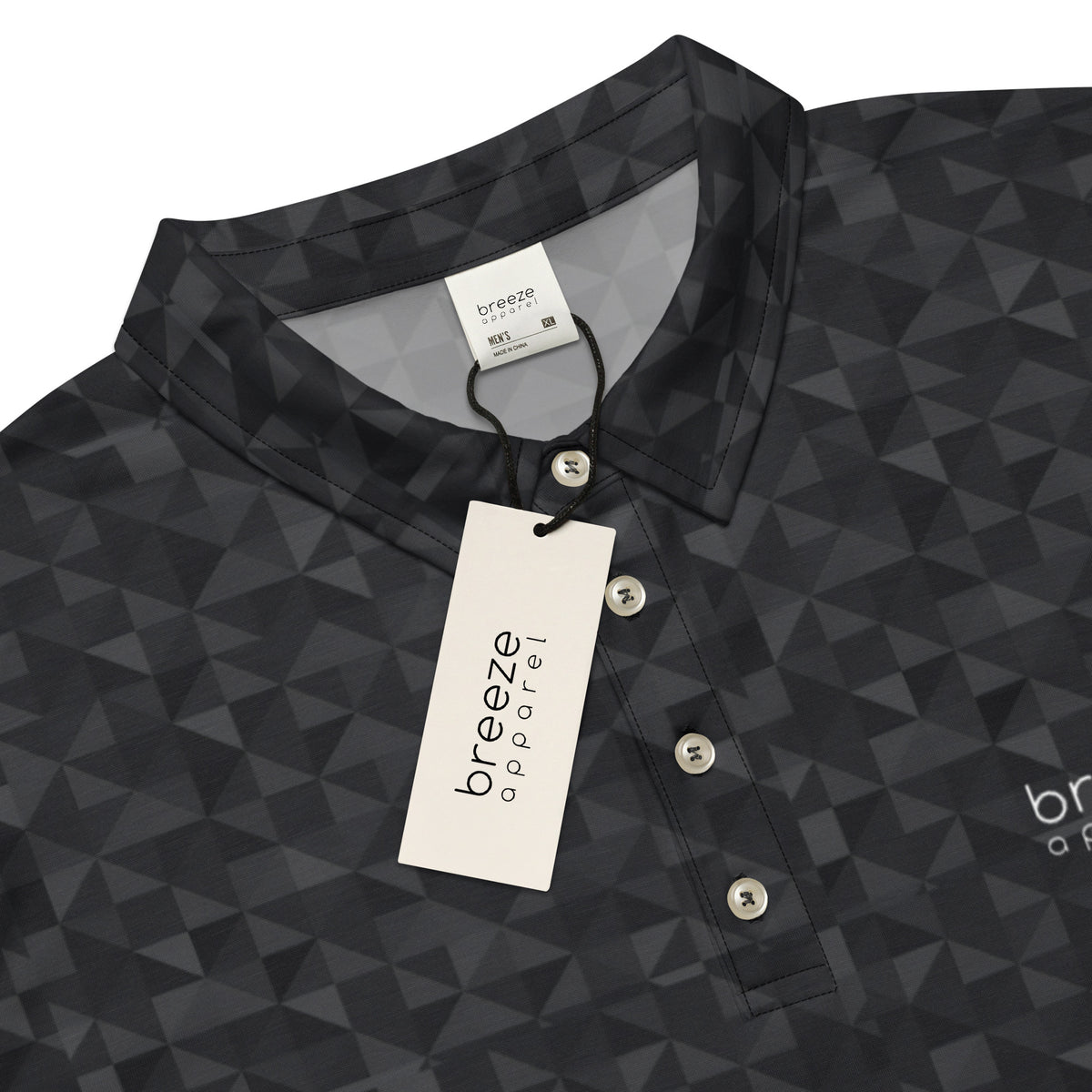 Close-up of tag area of polo shirt with dark-gray geometric pattern. White tag with 'breeze apparel' in black is attached.