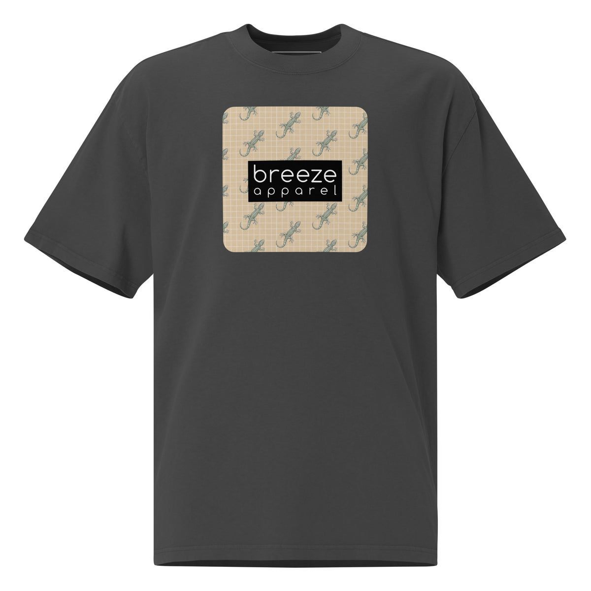Gray t-shirt with square over chest that contains pattern of green geckos set on beige background, overlaid with black, rectangular logo with white lettering.