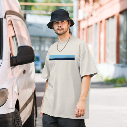 Man wearing white, oversized t-shirt with stripe across chest.