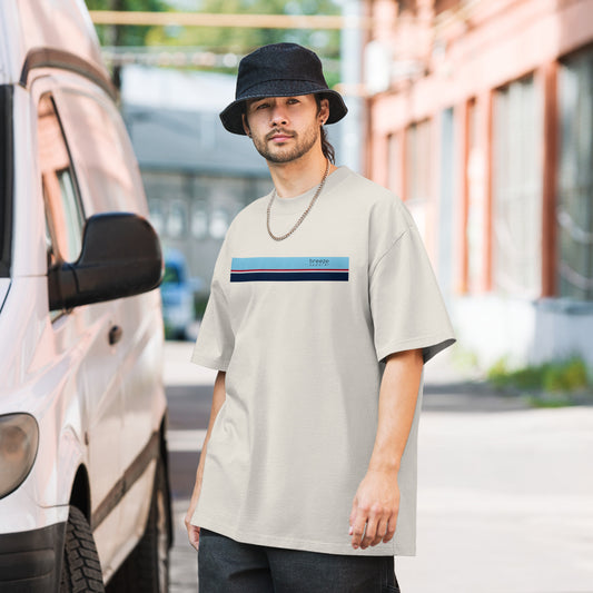 Man wearing white, oversized t-shirt with stripe across chest.