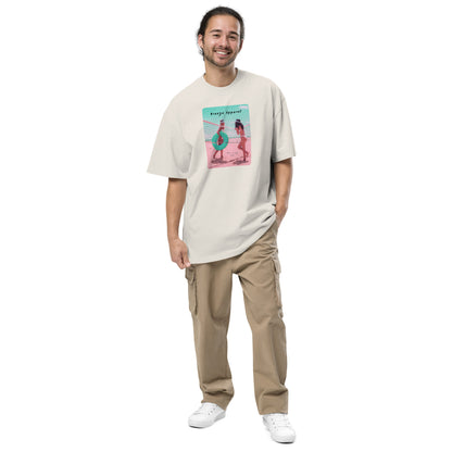 Man wearing white, oversized t-shirt with graphic of two women on beach.