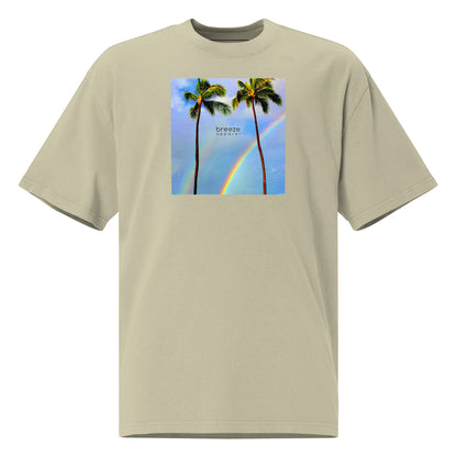 Green t-shirt with graphic of two palm trees with rainbow in background.