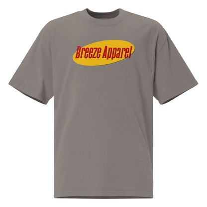 Gray t-shirt with graphic of red lettering set over yellow oval.