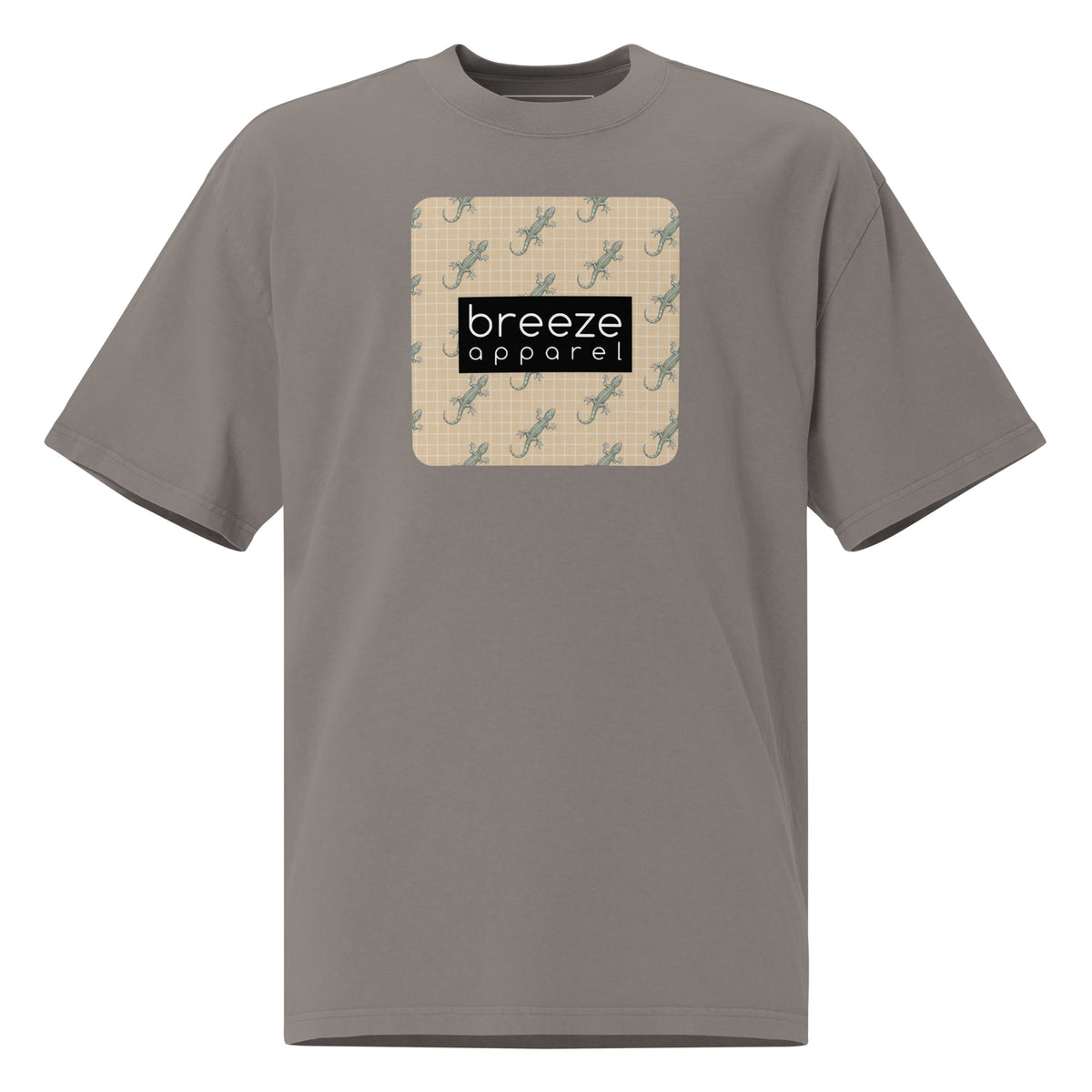 Gray t-shirt with square over chest that contains pattern of green geckos set on beige background, overlaid with black, rectangular logo with white lettering.