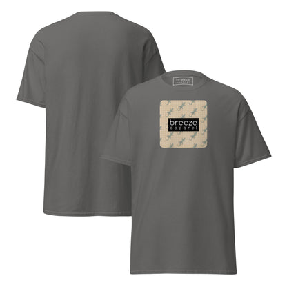 Gray t-shirt with square over chest that contains pattern of green geckos set on beige background, overlaid with black, rectangular logo with white lettering. Plain backside also shown.