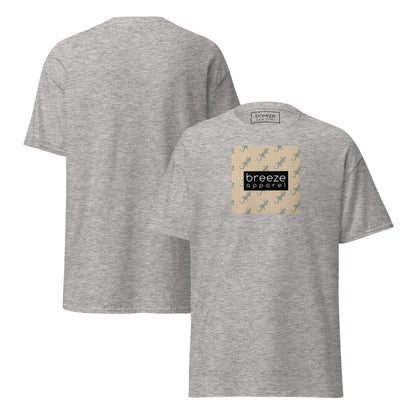 Gray t-shirt with square over chest that contains pattern of green geckos set on beige background, overlaid with black, rectangular logo with white lettering. Plain backside also shown.