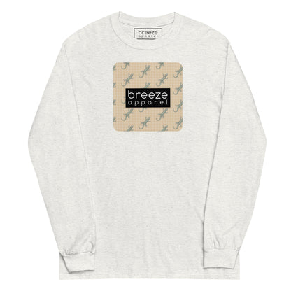 White, long-sleeved shirt with square over chest that contains pattern of green geckos set on beige background, overlaid with black, rectangular logo with white lettering.