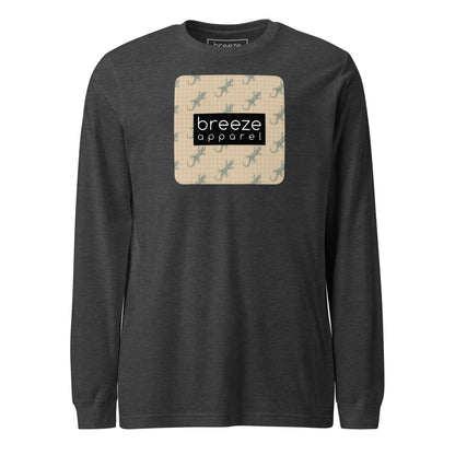 Gray, long-sleeved shirt with square over chest that contains pattern of green geckos set on beige background, overlaid with black, rectangular logo with white lettering.