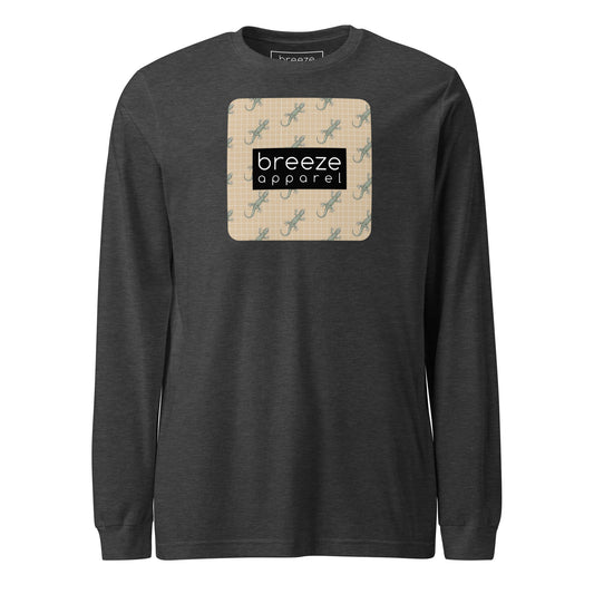 Gray, long-sleeved shirt with square over chest that contains pattern of green geckos set on beige background, overlaid with black, rectangular logo with white lettering.