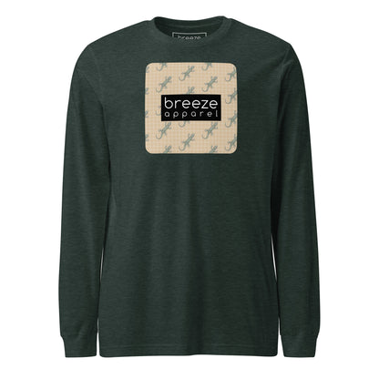 Green, long-sleeved shirt with square over chest that contains pattern of green geckos set on beige background, overlaid with black, rectangular logo with white lettering.
