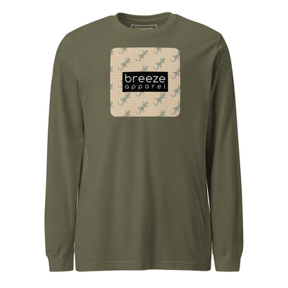 Green, long-sleeved shirt with square over chest that contains pattern of green geckos set on beige background, overlaid with black, rectangular logo with white lettering.
