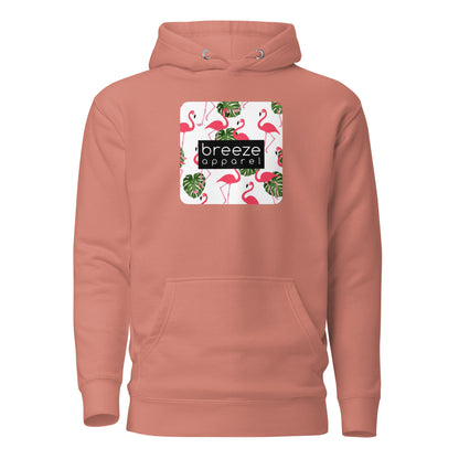 Pink hoodie with graphic of flamingos and green palm leaves set on a white background and overlaid with a black, rectangular logo.