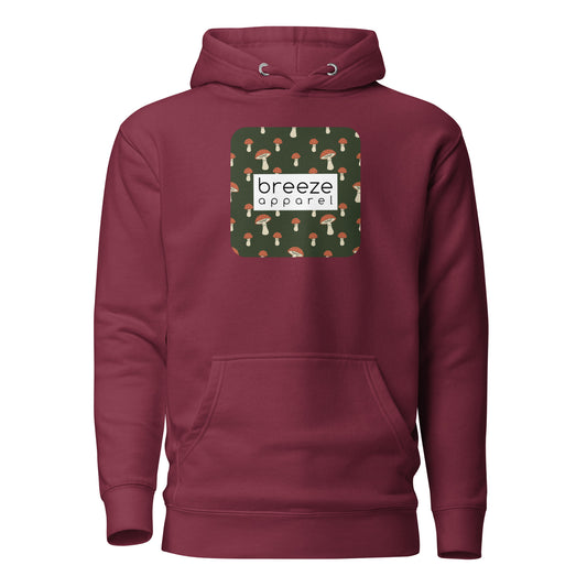Maroon hoodie with graphic of mushrooms set on a green background and overlaid with a white, rectangular logo.