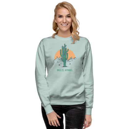 Woman wearing silver-blue sweatshirt with graphic of cactus and sun.