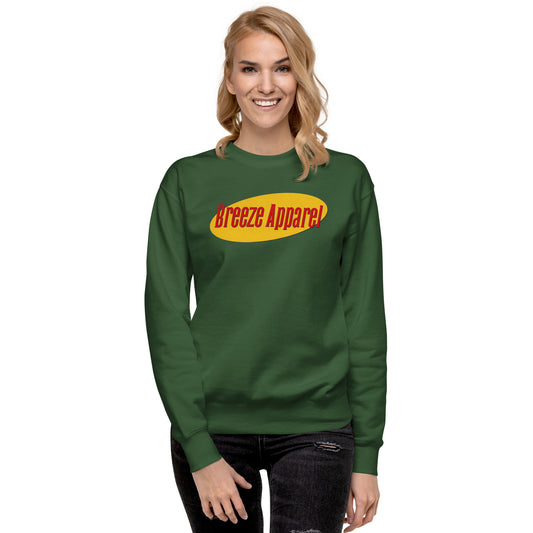 Woman wearing green sweatshirt with graphic of red lettering set on a yellow oval.