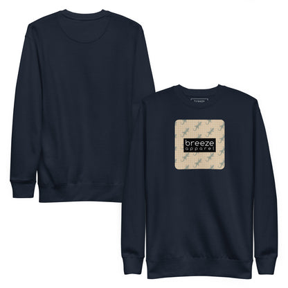 Navy sweatshirt with square over chest that contains pattern of green geckos set on beige background, overlaid with black, rectangular logo with white lettering. Plain back also shown.