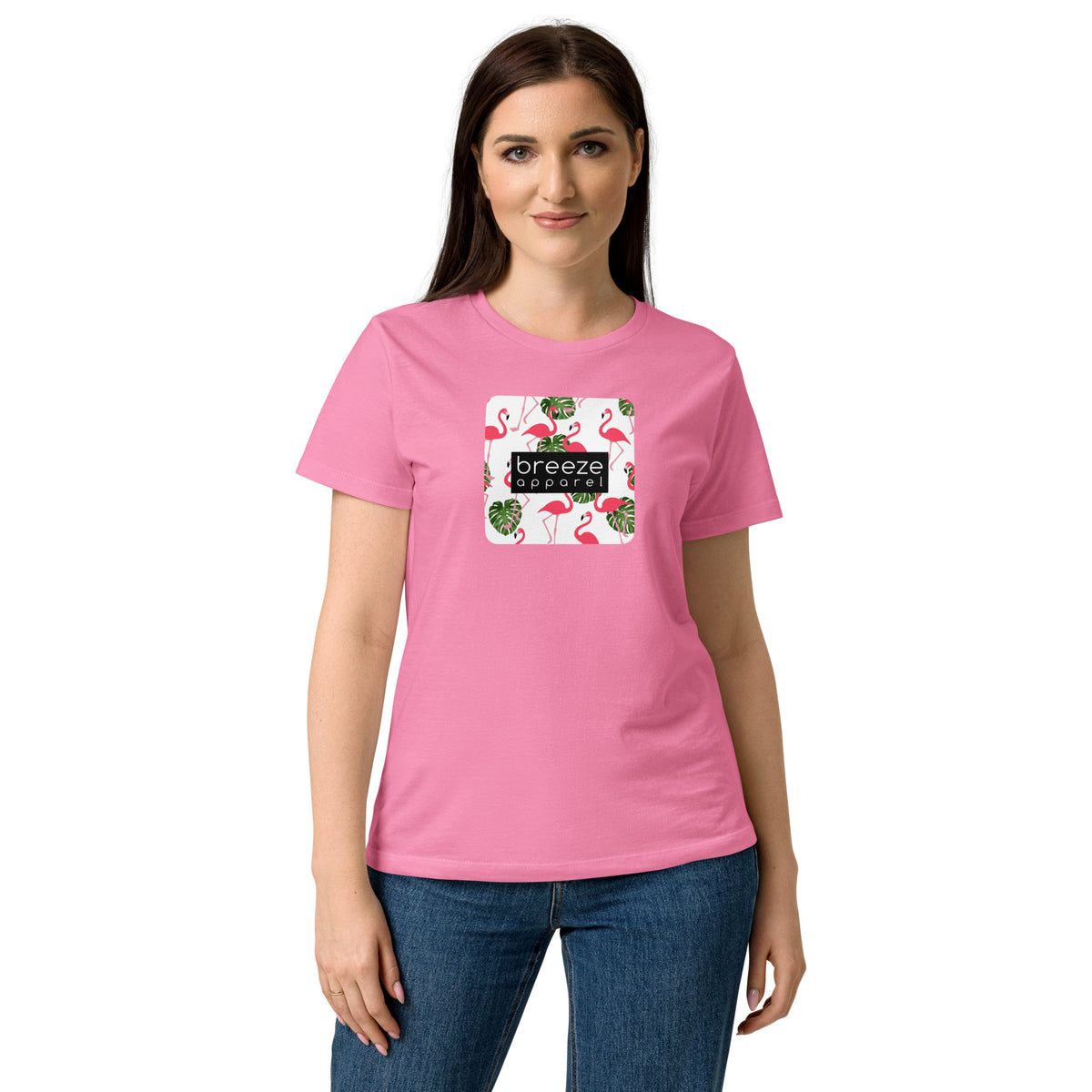 Woman wearing pink t-shirt with graphic of flamingos overlaid with a black logo.