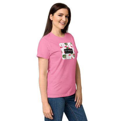 Woman wearing pink t-shirt with graphic of flamingos overlaid with a black logo.