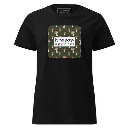 Black t-shirt with graphic of mushroom pattern set on a green background, overlaid with a white box with 'breeze apparel' in black inside.